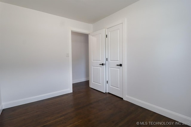 209 E Falletti Ave, Claremore, OK 74017 - spare room featuring dark wood-style floors and baseboards