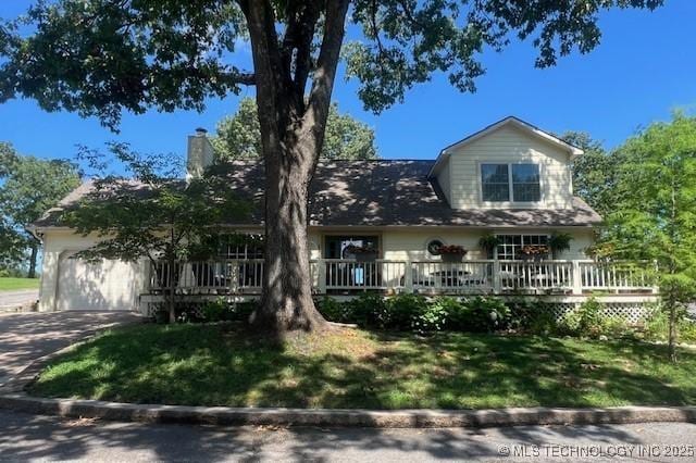 31990 S 624th Pl Unit 65, Grove, OK 74344 - view of front of property featuring a garage, driveway, a front yard, and a deck