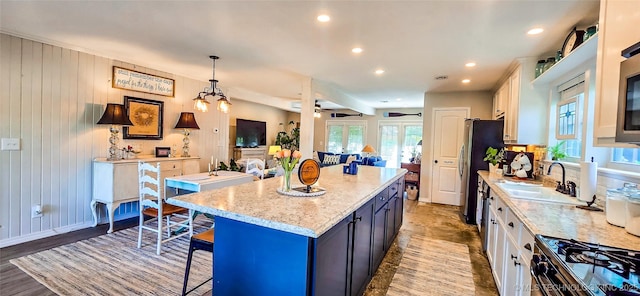 108256 Pike St, Checotah, OK 74426 - kitchen featuring a kitchen breakfast bar, a center island, white cabinets, light stone counters, and recessed lighting