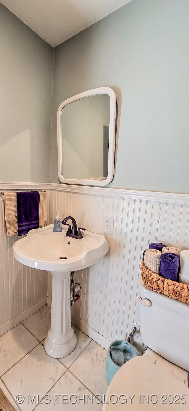 108256 Pike St, Checotah, OK 74426 - half bathroom with marble look tile flooring, wainscoting, and wooden walls