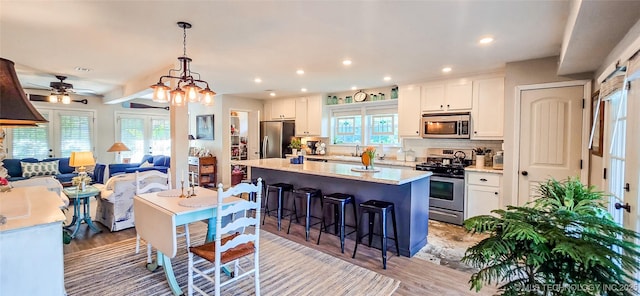 108256 Pike St, Checotah, OK 74426 - kitchen with stainless steel appliances, a breakfast bar, a kitchen island, white cabinets, and recessed lighting