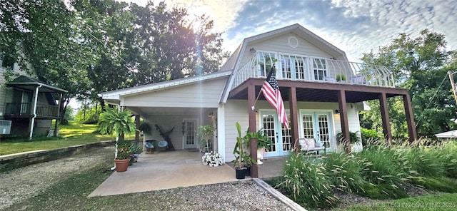 108256 Pike St, Checotah, OK 74426 - view of front of home featuring french doors, a gambrel roof, an attached carport, and driveway