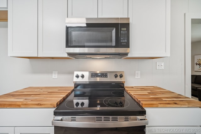 2837 E Admiral Ct, Tulsa, OK 74110 - kitchen with stainless steel appliances, butcher block countertops, tasteful backsplash, and white cabinetry