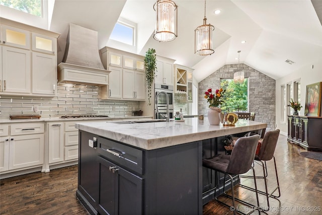 4603 E 118th Pl, Tulsa, OK 74137 - kitchen featuring custom range hood, lofted ceiling, plenty of natural light, and an island with sink