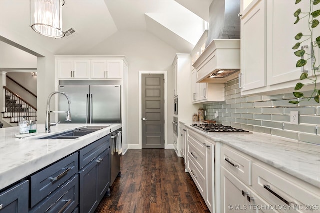 4603 E 118th Pl, Tulsa, OK 74137 - kitchen featuring custom exhaust hood, stainless steel appliances, white cabinetry, decorative backsplash, and vaulted ceiling