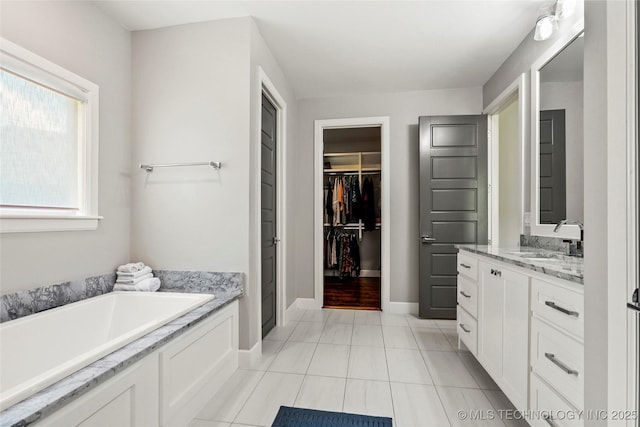 4603 E 118th Pl, Tulsa, OK 74137 - bathroom featuring a bath, vanity, a spacious closet, and tile patterned flooring