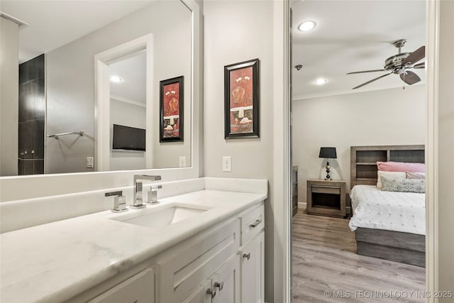 4603 E 118th Pl, Tulsa, OK 74137 - bathroom with vanity, ornamental molding, a ceiling fan, wood finished floors, and recessed lighting