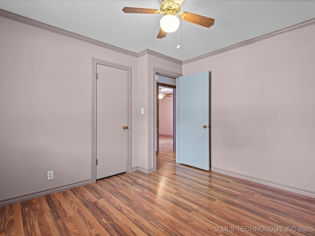 927 Macklyn Ln, Bartlesville, OK 74006 - unfurnished bedroom featuring wood finished floors, ornamental molding, ceiling fan, and a textured ceiling