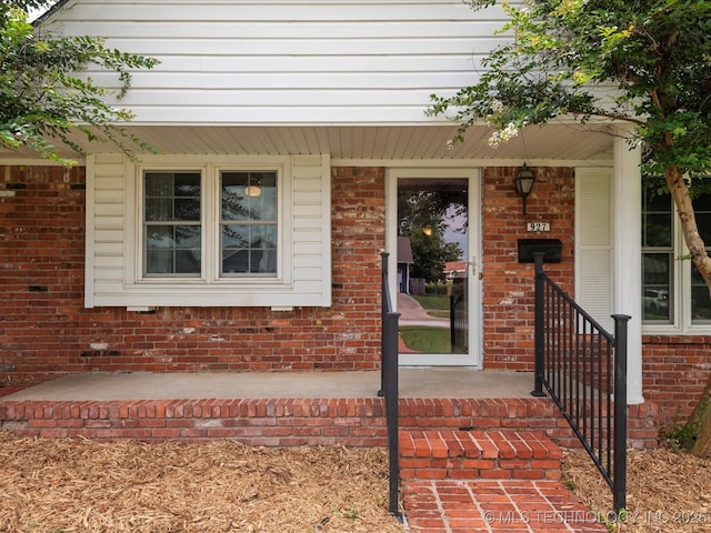 927 Macklyn Ln, Bartlesville, OK 74006 - view of exterior entry featuring brick siding and a porch
