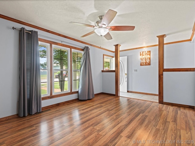 927 Macklyn Ln, Bartlesville, OK 74006 - empty room featuring crown molding, wood finished floors, ceiling fan, a textured ceiling, and a chandelier