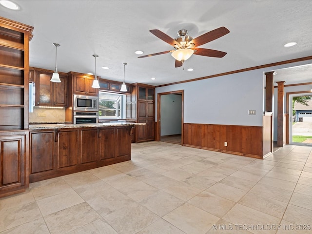 927 Macklyn Ln, Bartlesville, OK 74006 - kitchen featuring stainless steel appliances, wainscoting, ornamental molding, glass insert cabinets, and light stone countertops