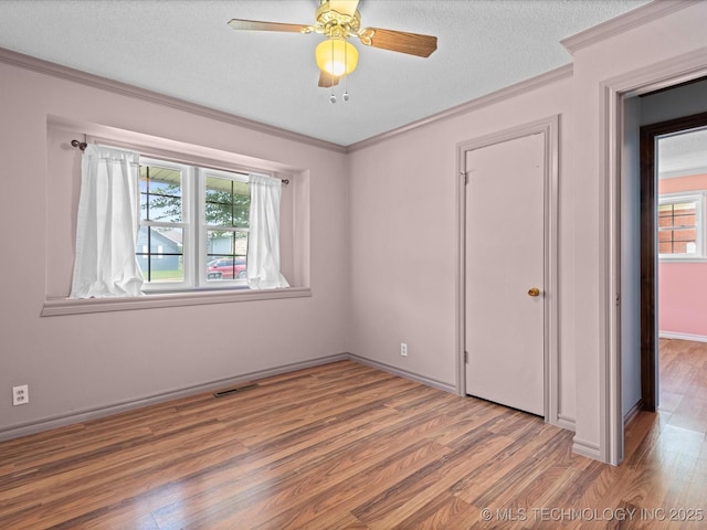 927 Macklyn Ln, Bartlesville, OK 74006 - spare room with crown molding, wood finished floors, healthy amount of natural light, a textured ceiling, and ceiling fan