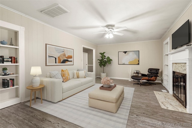 2900 S Cedar Ct, Broken Arrow, OK 74012 - living area featuring a fireplace, built in shelves, wood finished floors, ornamental molding, and ceiling fan