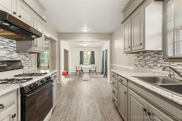 2900 S Cedar Ct, Broken Arrow, OK 74012 - kitchen with white gas range oven, range hood, light wood-style flooring, and decorative backsplash