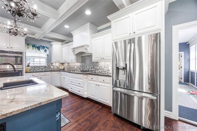 1528 Smysor Dr, Bartlesville, OK 74006 - kitchen with stainless steel appliances, dark wood-type flooring, a chandelier, light stone counters, and tasteful backsplash