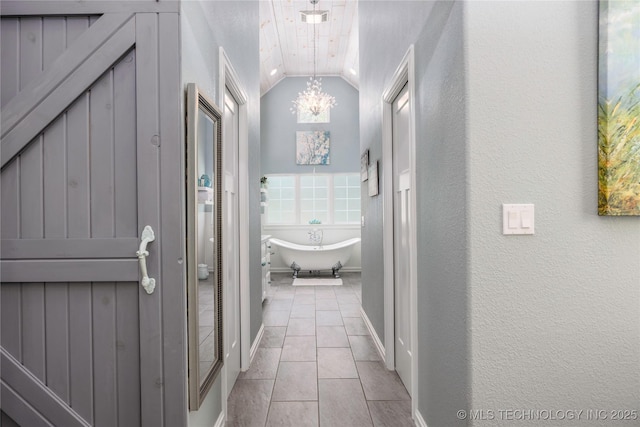 1528 Smysor Dr, Bartlesville, OK 74006 - bathroom featuring lofted ceiling, a chandelier, a freestanding bath, tile patterned floors, and a textured wall