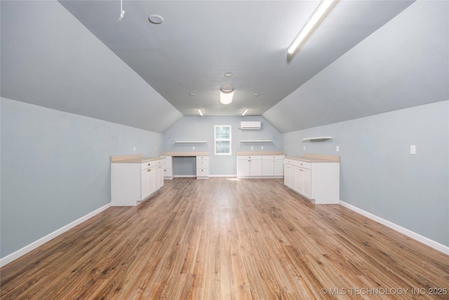 1528 Smysor Dr, Bartlesville, OK 74006 - additional living space featuring light wood finished floors, lofted ceiling, and an AC wall unit