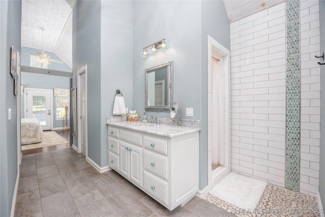 1528 Smysor Dr, Bartlesville, OK 74006 - ensuite bathroom with vaulted ceiling, vanity, a ceiling fan, tiled shower, and tile patterned floors