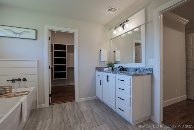 7141 E 138th Pl, Collinsville, OK 74021 - full bathroom featuring vanity, a bathtub, and a spacious closet