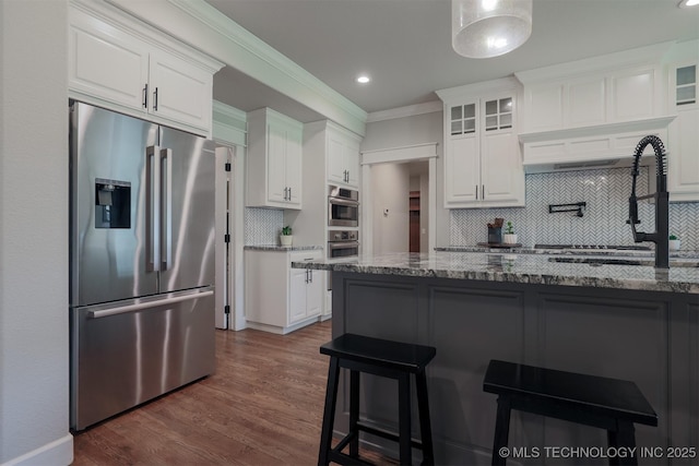 7141 E 138th Pl, Collinsville, OK 74021 - kitchen featuring high quality fridge, a kitchen breakfast bar, tasteful backsplash, glass insert cabinets, and white cabinets