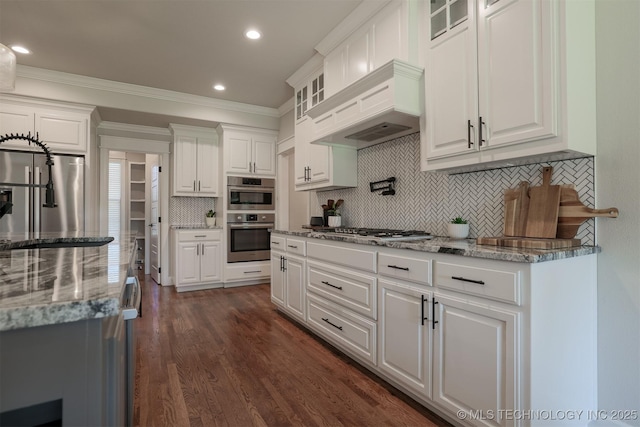 7141 E 138th Pl, Collinsville, OK 74021 - kitchen with appliances with stainless steel finishes, white cabinetry, glass insert cabinets, crown molding, and decorative backsplash
