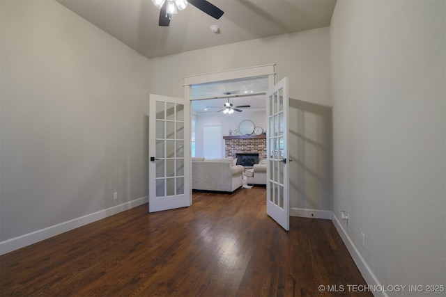 7141 E 138th Pl, Collinsville, OK 74021 - empty room with french doors, ceiling fan, dark wood-style floors, and a brick fireplace