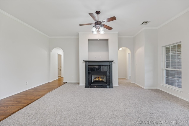 2629 S 13th St, Broken Arrow, OK 74012 - unfurnished living room featuring arched walkways, carpet flooring, crown molding, ceiling fan, and a fireplace