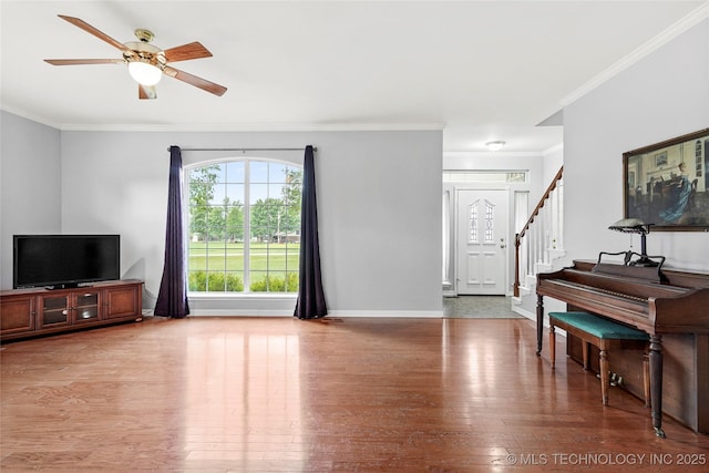 10672 E Canyon Oaks Ct, Claremore, OK 74017 - living area featuring crown molding, wood finished floors, ceiling fan, and stairs