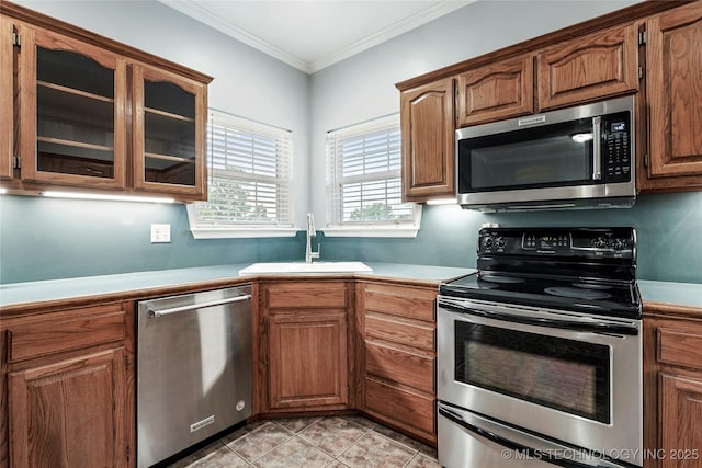 10672 E Canyon Oaks Ct, Claremore, OK 74017 - kitchen featuring stainless steel appliances, light countertops, glass insert cabinets, crown molding, and brown cabinetry