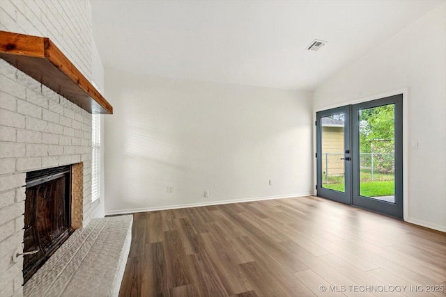 1847 W 57th Pl, Tulsa, OK 74107 - unfurnished living room featuring wood finished floors, lofted ceiling, a brick fireplace, and french doors