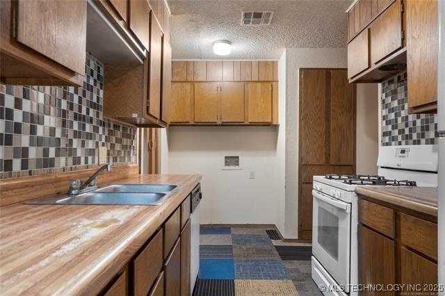2608 Hickory Bluff Rd, Sapulpa, OK 74066 - kitchen with white gas range oven, backsplash, a textured ceiling, wood counters, and stainless steel dishwasher