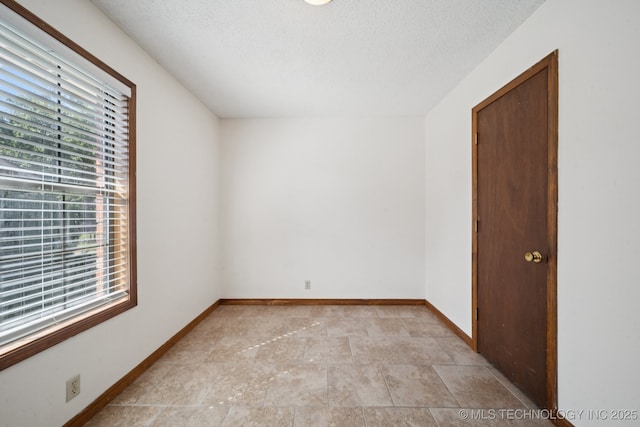 126 Birch Dr, Mannford, OK 74044 - spare room featuring plenty of natural light, a textured ceiling, and light stone finish flooring