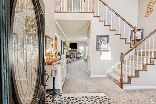 8702 N 140th Ter, Owasso, OK 74055 - carpeted foyer entrance featuring stairs, ornamental molding, and a fireplace