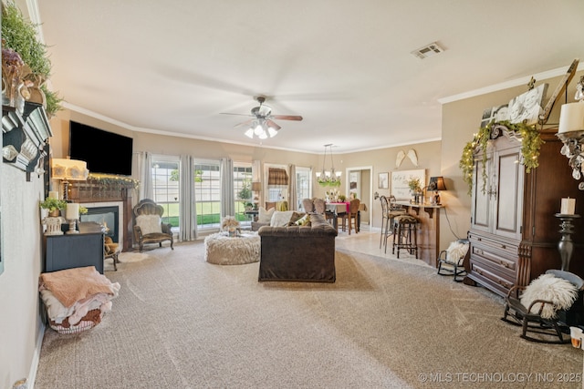 8702 N 140th Ter, Owasso, OK 74055 - carpeted living area with ceiling fan, a glass covered fireplace, crown molding, and a chandelier