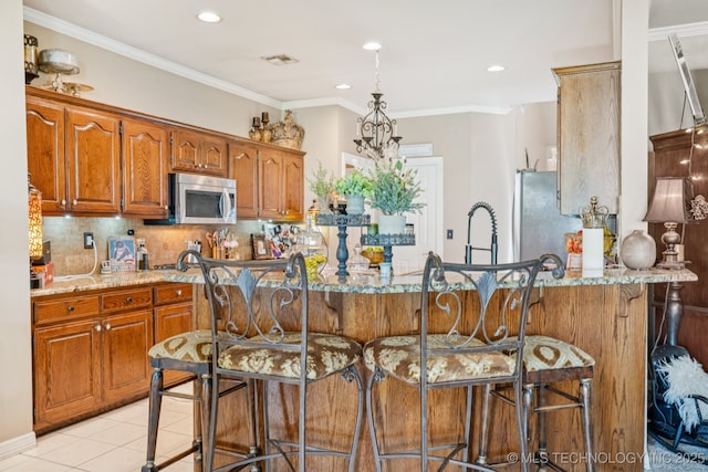 8702 N 140th Ter, Owasso, OK 74055 - kitchen with appliances with stainless steel finishes, light stone countertops, decorative backsplash, brown cabinets, and recessed lighting
