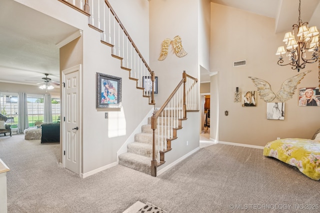 8702 N 140th Ter, Owasso, OK 74055 - staircase featuring carpet floors, ceiling fan, a high ceiling, and a chandelier