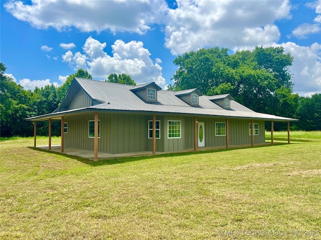 16547 County Road 1600, Ada, OK 74820 - view of side of property featuring board and batten siding, a lawn, and a patio