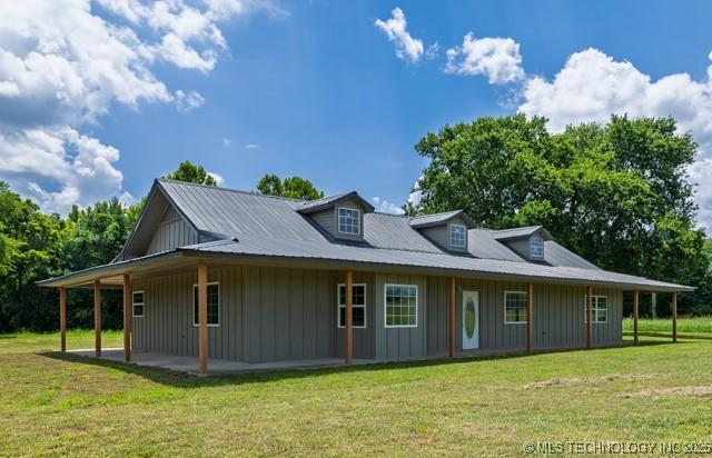 16547 County Road 1600, Ada, OK 74820 - view of front facade featuring board and batten siding, a front yard, and a patio