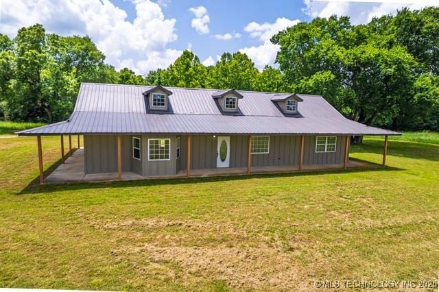16547 County Road 1600, Ada, OK 74820 - country-style home with board and batten siding, a front yard, view of scattered trees, and a metal roof
