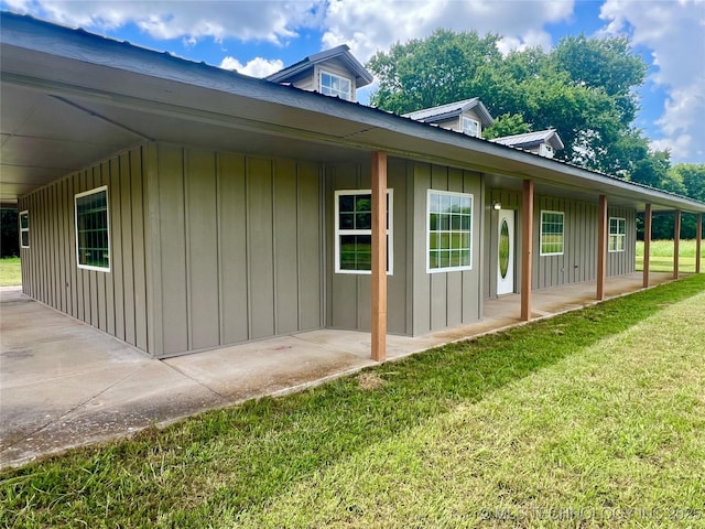 16547 County Road 1600, Ada, OK 74820 - view of home's exterior with a yard, board and batten siding, a metal roof, and a patio area