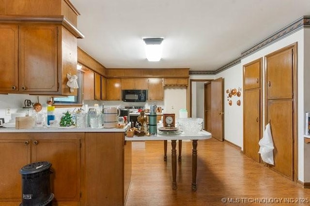 12725 S 168th E Ave, Broken Arrow, OK 74011 - kitchen featuring black microwave, brown cabinets, light wood finished floors, and light countertops