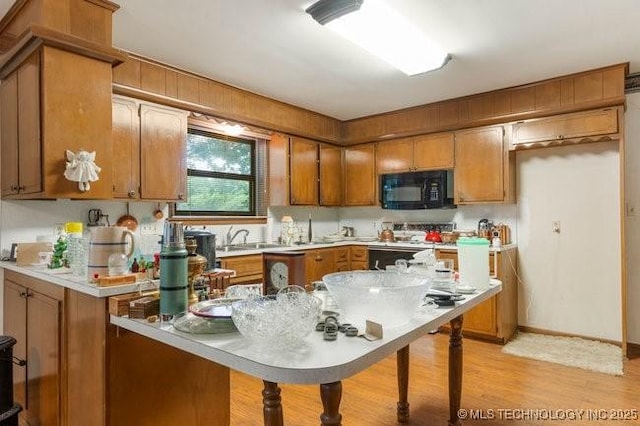 12725 S 168th E Ave, Broken Arrow, OK 74011 - kitchen with black microwave, brown cabinetry, light wood-style floors, and light countertops