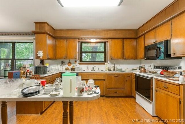 12725 S 168th E Ave, Broken Arrow, OK 74011 - kitchen with electric range, black microwave, and brown cabinetry