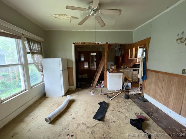 1225 S Quaker Ave, Tulsa, OK 74120 - spare room featuring plenty of natural light, wainscoting, a ceiling fan, and wooden walls