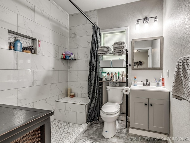 310 W Lee Ave, Sapulpa, OK 74066 - bathroom with vanity, a textured wall, and a tile shower