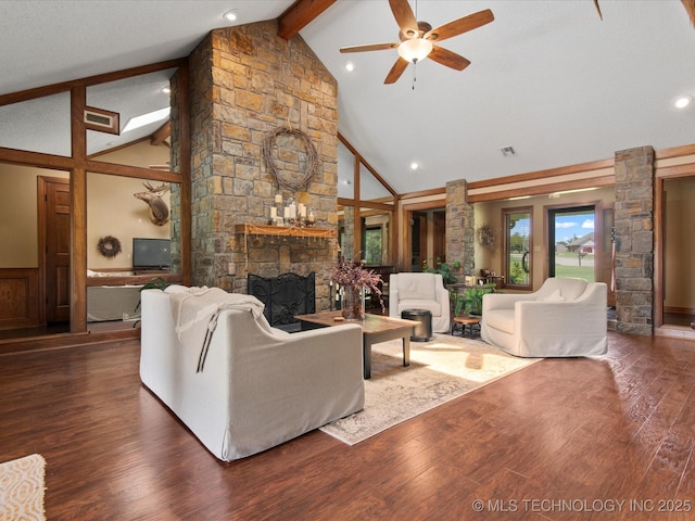 6429 Clear Creek Loop, Bartlesville, OK 74006 - living area featuring beamed ceiling, ceiling fan, a stone fireplace, wood finished floors, and high vaulted ceiling
