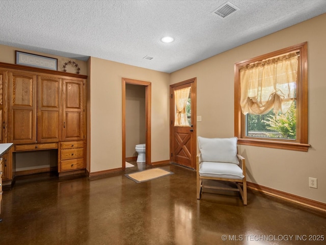 6429 Clear Creek Loop, Bartlesville, OK 74006 - living area with a textured ceiling, built in study area, concrete floors, and recessed lighting