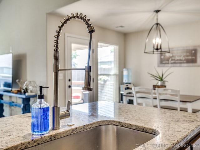 3409 E Quebec St, Broken Arrow, OK 74014 - kitchen with light stone countertops, hanging light fixtures, and a chandelier