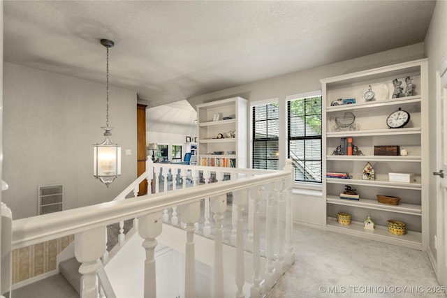 6530 E 106th St, Tulsa, OK 74133 - hall with light carpet, a textured ceiling, and an upstairs landing