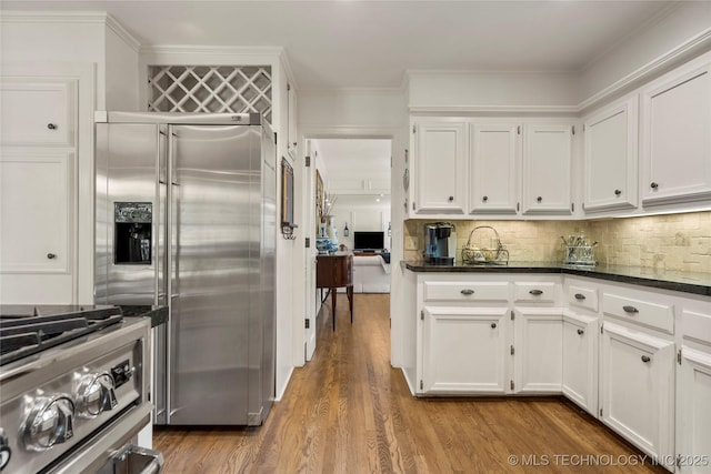 6530 E 106th St, Tulsa, OK 74133 - kitchen with appliances with stainless steel finishes, white cabinetry, tasteful backsplash, wood finished floors, and dark stone countertops